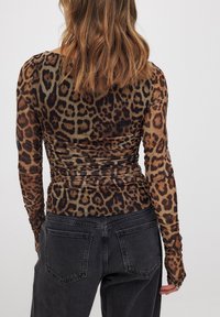 Long-sleeve leopard print top in brown and black mesh fabric, featuring a ruched design and fitted silhouette.