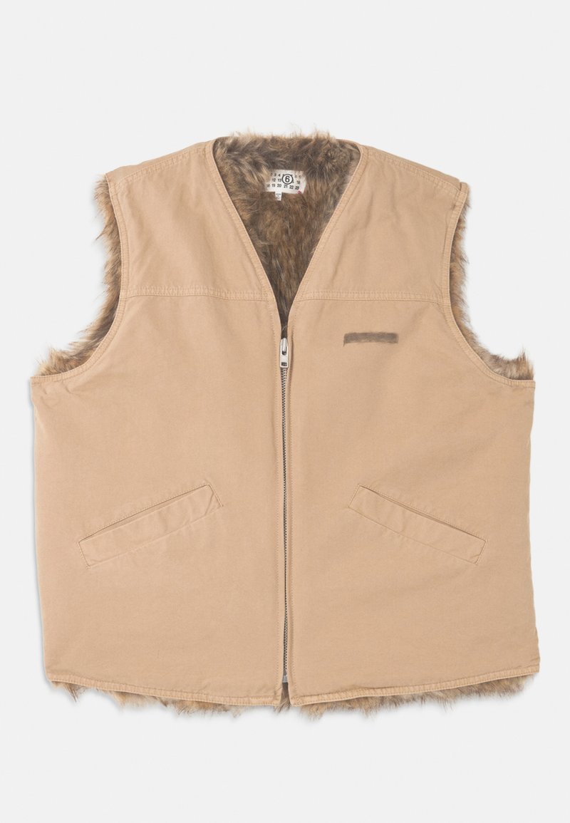 Beige vest with a zip front, featuring a soft, faux fur lining and open sides. Two front pockets for storage. Textured fabric detail.