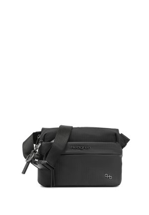 Sac bandoulière noir avec sangle réglable, poche avant zippée et logo Hedgren sur fond blanc.