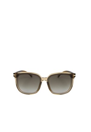 Occhiali da sole di forma quadrata con montature spesse beige traslucide e lenti a gradiente grigie, mostrati frontalmente su sfondo bianco.