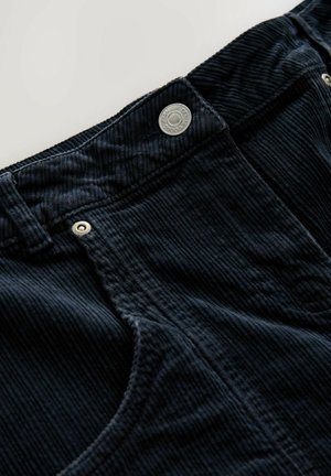 Pantalones de pana azul oscuro con cintura alta, textura de acanalado vertical, cierre de botón metálico y bolsillos frontales.
