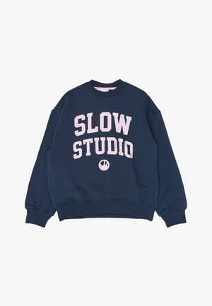 Mørkeblå crewneck sweatshirt med lyserød tekst "SLOW STUDIO" og et lille rundt logo centreret under teksten.