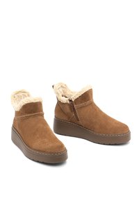 Tona velúr bokacsizma műszőrmével a gallérján, oldalsó cipzárral és vastag gumitalppal. Simább textúra, foltmentes dizájn.