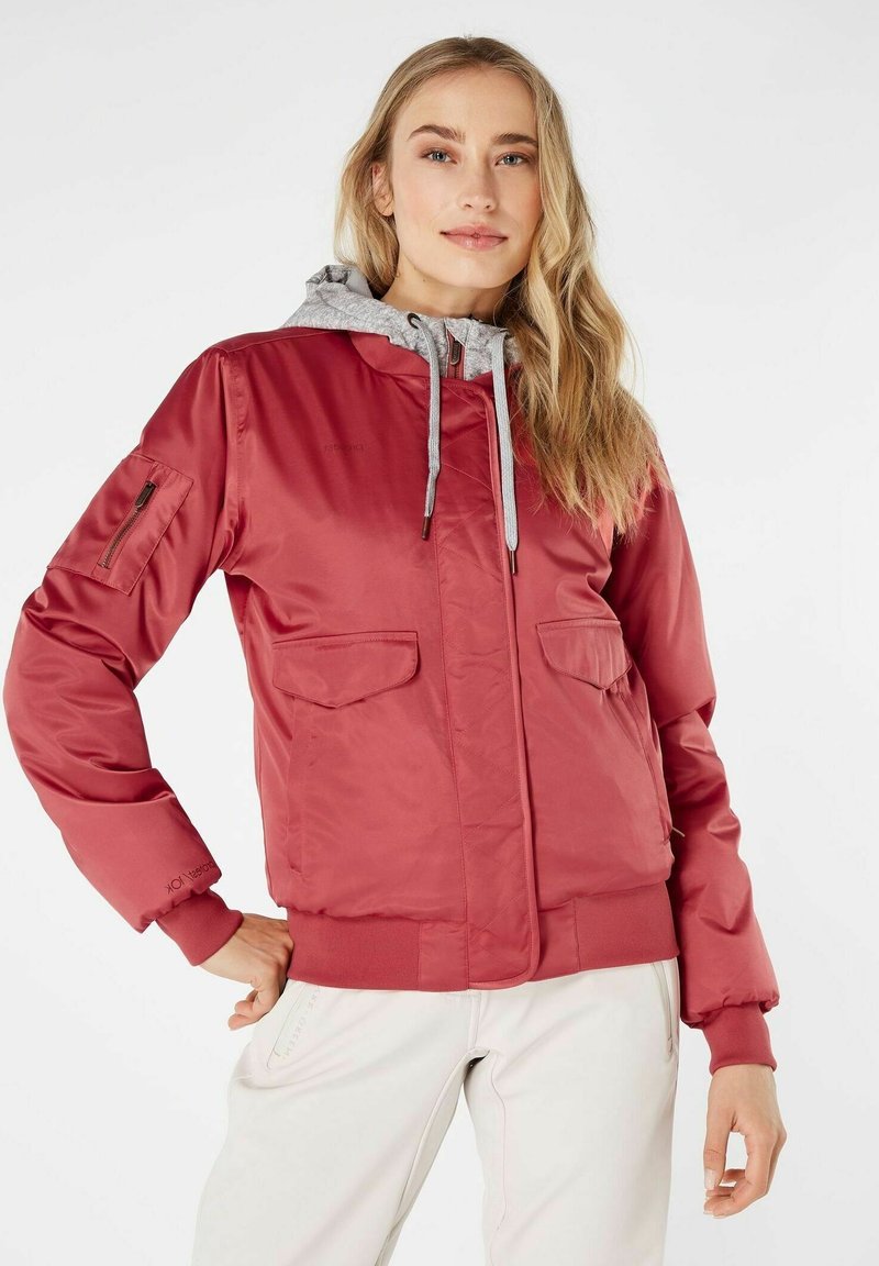 Chaqueta bomber roja con capucha gris, que cuenta con bolsillos con cremallera y solapa, puños acanalados y una textura suave y brillante.