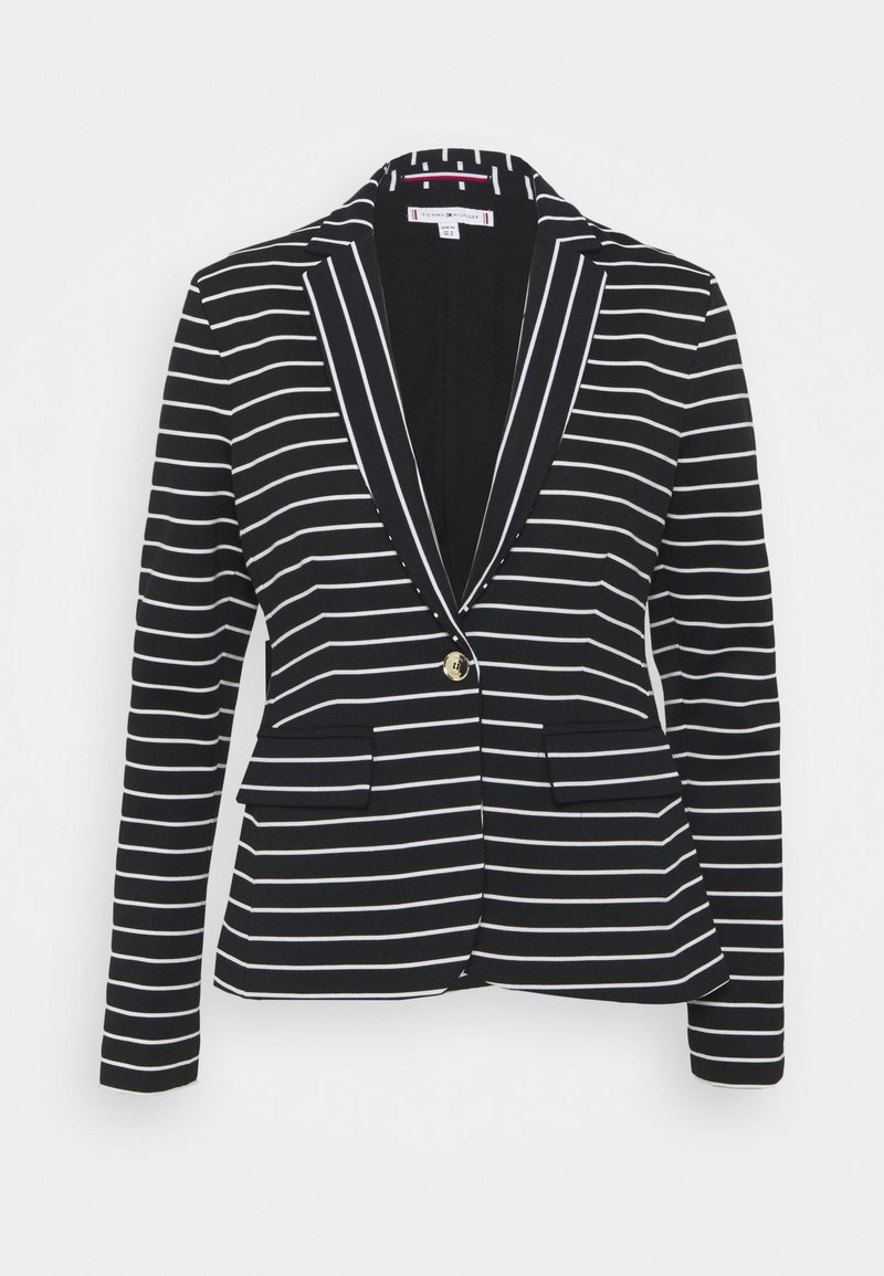 Blazer noir à rayures horizontales blanches, fermeture par un bouton doré unique, col à revers en encoche et poches avant à rabat.