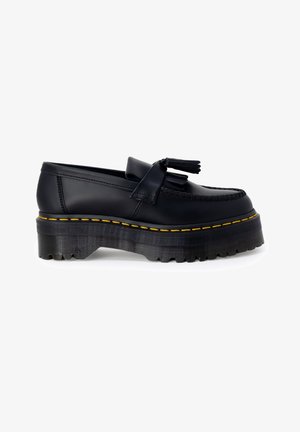 Mocassin à plateforme en cuir noir avec semelle épaisse crantée, surpiqûres jaunes, détail pompon et couture moc toe, présenté de profil sur fond blanc.