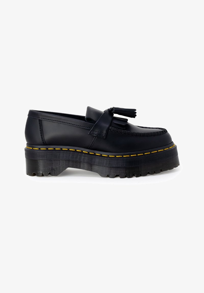 Mocassin à plateforme en cuir noir avec semelle épaisse crantée, surpiqûres jaunes, détail pompon et couture moc toe, présenté de profil sur fond blanc.