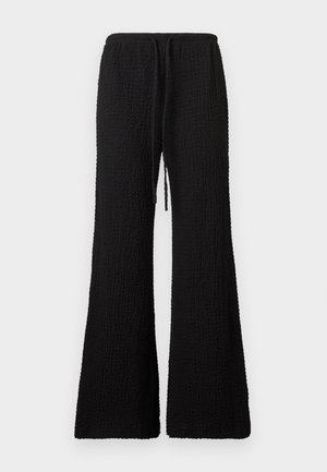 Fekete texturált, széles szárú nadrág rugalmas derékpánttal és elöl megkötős zsinórral, egyszínű világos háttér előtt bemutatva.