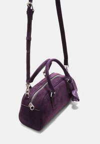 Lila Wildleder-Handtasche mit doppelten Griffen, abnehmbarem Schultergurt, silbernem Reißverschluss und dekorativem Quasten mit Nieten. Rechteckige Form.