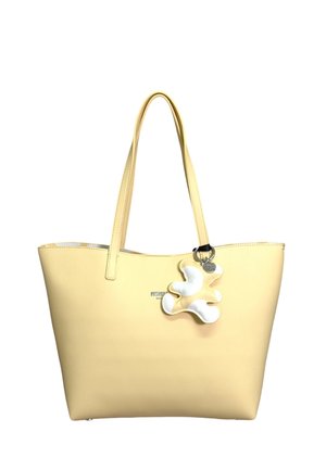 Borsa tote in pelle giallo chiaro con manici lunghi e portachiavi a forma astratta bianco e giallo attaccato.