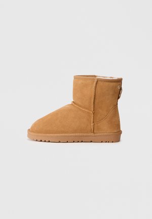 Varren tan suede-nilkkuri, jossa on pehmeä vuori, pyöreä varvas, tikatut yksityiskohdat ja kumipohja; takaosassa on silmukka helppoa pukemista varten.