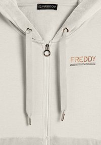 Felpa zip con cappuccio grigio chiaro, dotata di lacci e con un piccolo logo "FREDDY" in strass color rame e nero sul petto.