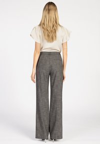 Grijze geruite hoge taille broek met wijde pijpen, voorzien van een gladde stoftextuur en subtiele gele accenten. Achteraanzicht weergegeven.