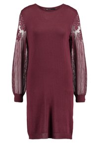 Burgundské šaty s dlouhými průhlednými krajkovými rukávy a žebrovanými manžetami. Měkká pletená tkanina, kulatý výstřih a délka ke kolenům.