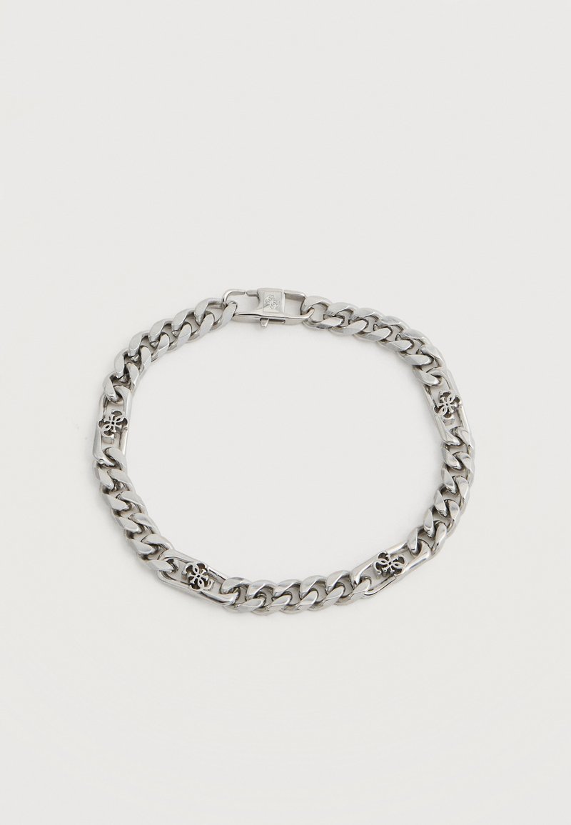 Bracelet en chaîne argentée avec des maillons larges et quatre petits charms décoratifs en forme de fleurs, espacés uniformément.