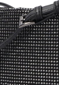 Zwarte handtas met een gestikte oppervlakte en metalen accenten, een slank ontwerp en een gestructureerde afwerking. Verstelbare schouderriem met een gesp detail.