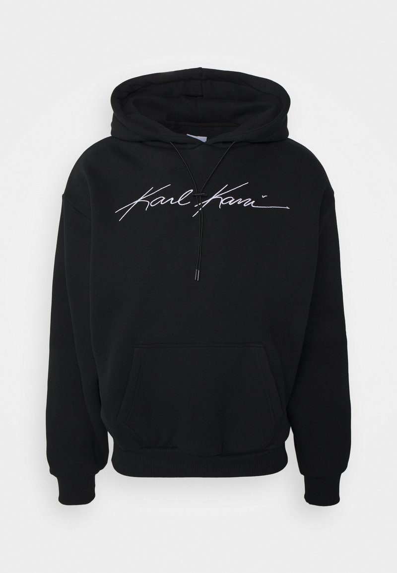 Sweat à capuche noir avec poche kangourou à l'avant et logo "Karl Kani" en écriture cursive blanche sur la poitrine, avec cordons de serrage sur la capuche.