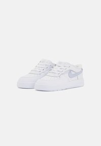 Bele tenisice iz usnjene bele barve z teksturiranim zaključkom, okroglo konico, vezalkami in svetlo modrim Nike logotipom. Imajo debele gumijaste podplate.