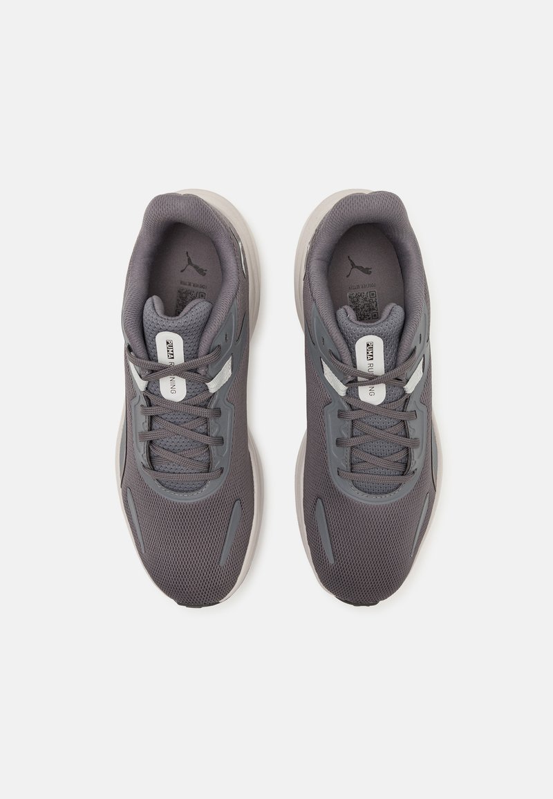 Zapatillas deportivas grises con parte superior de malla, cierre de cordones, cuello acolchado y acentos blancos. Diseño ligero adecuado para el uso activo.