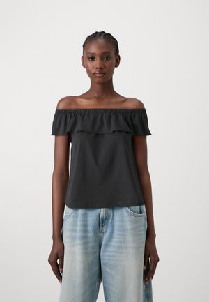 Svart off-shoulder topp med volangdetaljer, laget av myk stoff, kombinert med lys blå vidbukser. En enkel og uformell design.