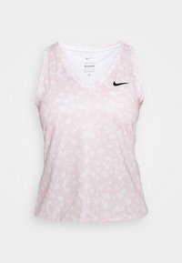 Růžový sportovní tank top bez rukávů s v-výstřihem, který má texturovaný vzor a černé logo Nike na horní levé straně.