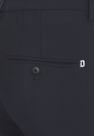 Pantaloni blu navy con una tasca posteriore dotata di un bottone nero e un accento "D" in argento. Tessuto dalla superficie liscia, design sartoriale e linee pulite.
