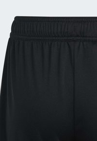 Schwarze Sporthosen haben eine glatte Textur, einen elastischen Bund mit geraffter Naht und eine lockere Passform für zusätzlichen Komfort.