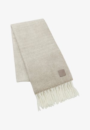 Écharpe beige en tissu doux, au toucher lisse et avec des bords blancs frangés. Petite étiquette en cuir avec la marque "HUGO" attachée.