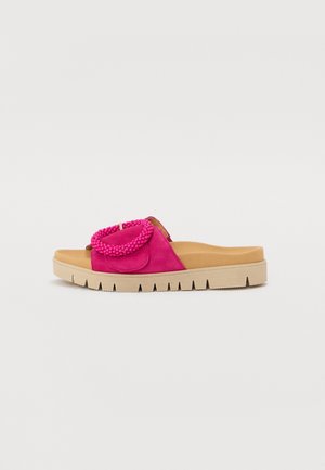 Flad slidesandal med beige sål, tan indlægssål og lys pink overdel med en struktureret cirkulær udsmykning.