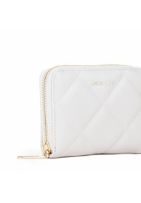 Portafoglio bianco trapuntato con zip e accessori dorati, caratterizzato da motivi a rombi cuciti e logo del brand impresso, design compatto.