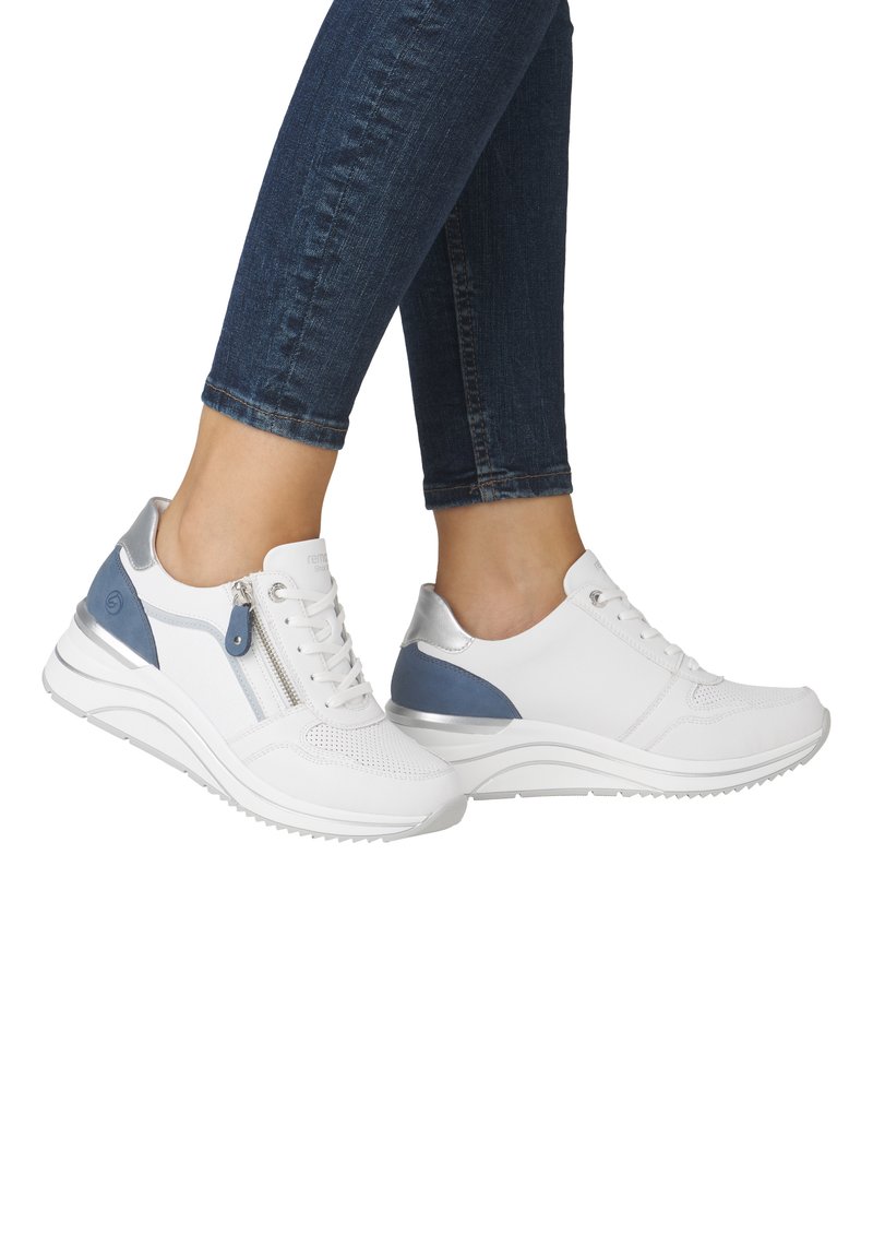 Sneakers bianchi con superficie texturizzata, dotati di accenti blu e argento, cerniera laterale e una robusta suola in gomma per un'ulteriore ammortizzazione.
