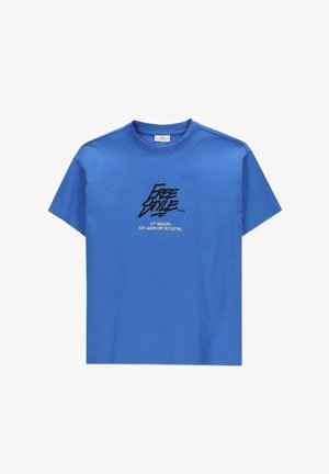 Niebieski t-shirt z krótkim rękawem z czarnym tekstem w stylu graffiti "Free Style" i mniejszym białym tekstem poniżej o treści "Nie wandalizm, tylko agresywna dekoracja."