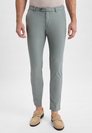 Chino grigi chiari con una vestibilità slim, realizzati in un tessuto morbido. Presentano una chiusura con bottone, tasche laterali e un design minimalista.