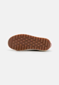 Hnědá gumová podrážka s hexagonálním vzorem a různými texturami, bílé boční okraje a červený akcent na patě.