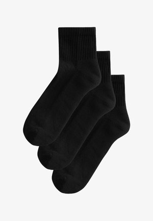 Schwarze Baumwollsocken mit einem gerippten Bündchen, glatter Textur und abgerundetem Zehenbereich. Set aus drei Paaren, gestapelt.