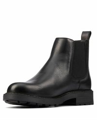 Stivale Chelsea in pelle nera con pannelli laterali elastici, punta arrotondata, superficie strutturata e suola in gomma resistente. Design minimalista e costruzione robusta.