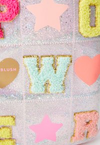 Pastellfärgad väska med glittriga, texturerade bokstäver och former. Innehåller en grön fluffig "W", en rosa stjärna, ett rosa hjärta och gyllene accenter.