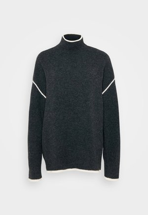 Mørkegrå genser med høy krage, med en hvit aksentstripe over skuldrene og kontrasterende hvite kanter ved mansjettene og bunnen.