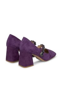 Paarse suede block-heeled schoenen met een puntige neus en een decoratieve band met donkere kralen en accenten bij de enkel.