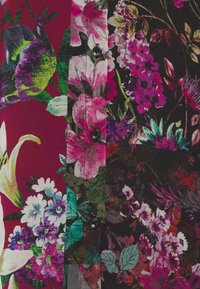 Primo piano di un tessuto floreale multicolore con fiori rosa, viola e bianchi, foglie verdi e bottoni neri disposti in una colonna verticale su uno sfondo rosso scuro e nero.