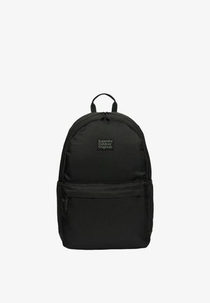 Czarny plecak Superdry Outdoor Originals z górnym uchwytem, przednią kieszenią na zamek błyskawiczny oraz główną komorą na zamek, na białym tle.