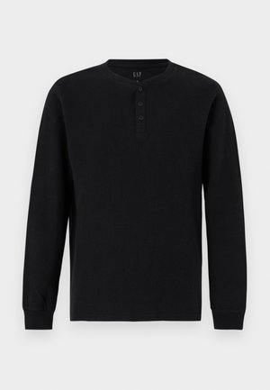 Schwarzes Henley-Langarmshirt mit drei Knöpfen und gerippten Bündchen, dargestellt vor einem schlichten hellgrauen Hintergrund.