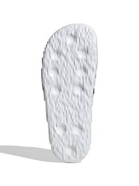 Bela gumijasta podplat sandalov z teksturirano površino z različnimi izbočenimi vzorci za oprijem, okroglo obliko in središčno odtočno luknjo.