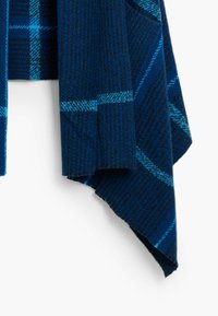 Écharpe à carreaux bleu marine avec un motif texturé et des accents bleus clairs. Le matériau semble doux, avec un design drapé et des bords frangés.