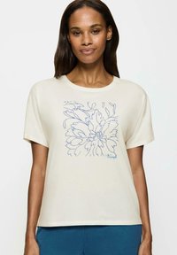 Kremowa koszulka z krótkim rękawem z niebieskim kwiatowym wzorem i logo "Triumph". Miękka tkanina, okrągły dekolt, luźny krój.