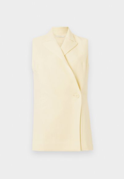 Käetuks kollane bleiser, millel on sisselõikega krae, ühe nupuga sulgemine ja kohandatud lõige. Pehme kangas sileda tekstuuriga.