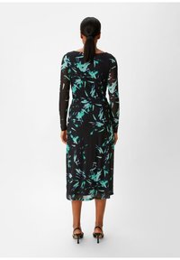 Langärmliges Kleid in Schwarz mit einem grünen und blauen abstrakten Blumenmuster, mit tailliertem Schnitt und knielanger Länge. Glattes, leichtes Material.