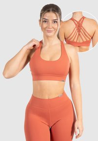 Conjunto de sujetador y leggings en color óxido, con una textura suave, una banda ancha y un diseño de tirantes cruzados en la parte posterior para mayor soporte.