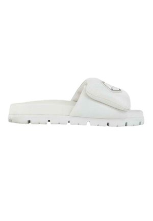 Witte slideslipper met dikke zool en brede gevoerde band met een klein aangehecht tasje met een metalen logoplaat.