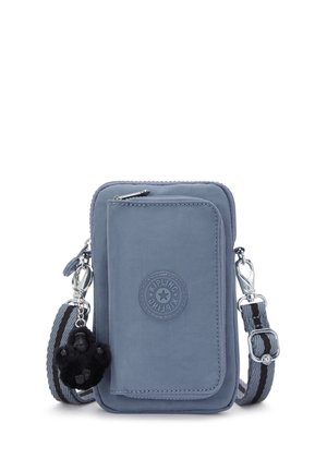 Small blue crossbody bag with front flap, zipper compartments, adjustable striped strap, and black gorilla keychain charm.